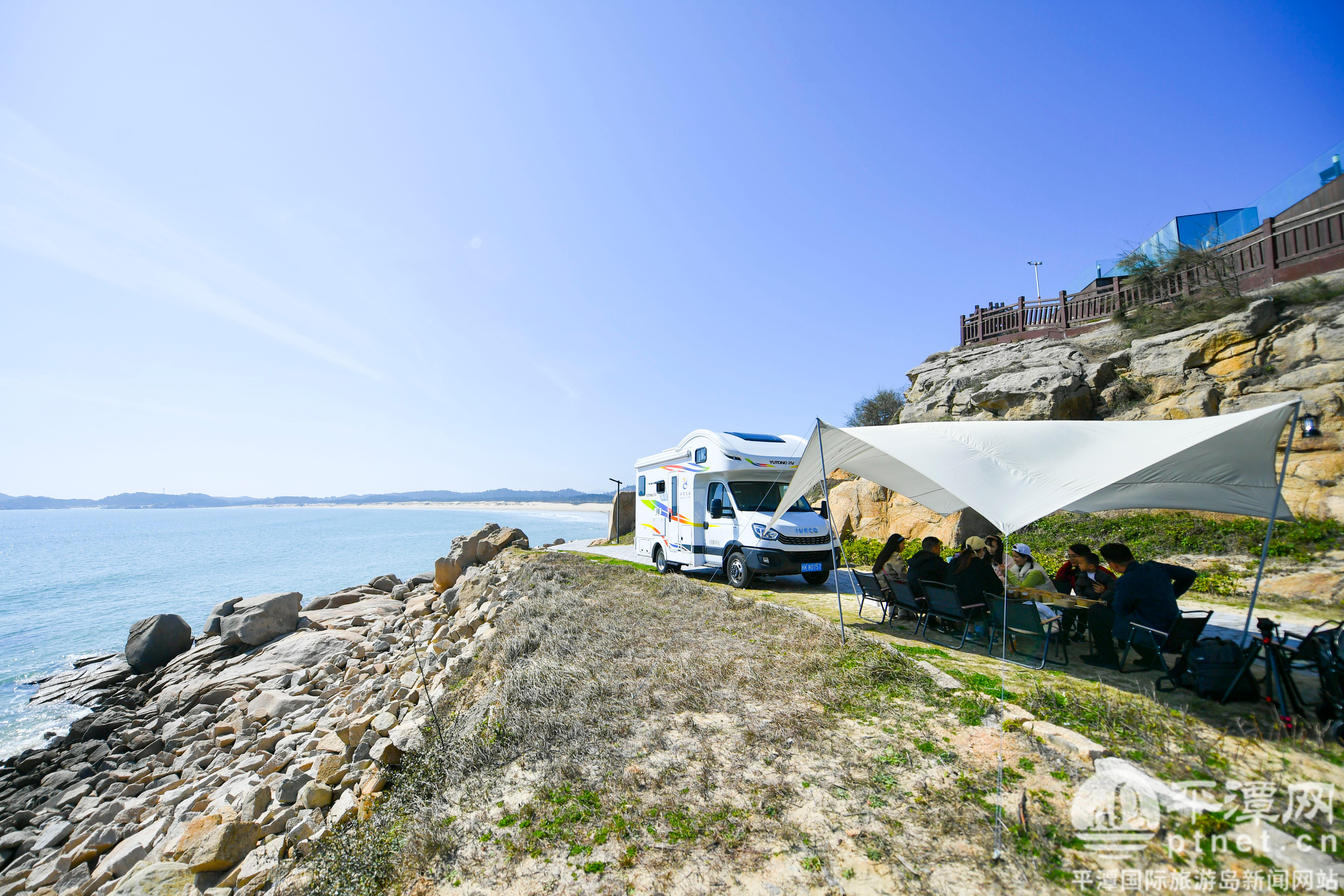 在坛南湾景区,游客开着房车到海边露营.
