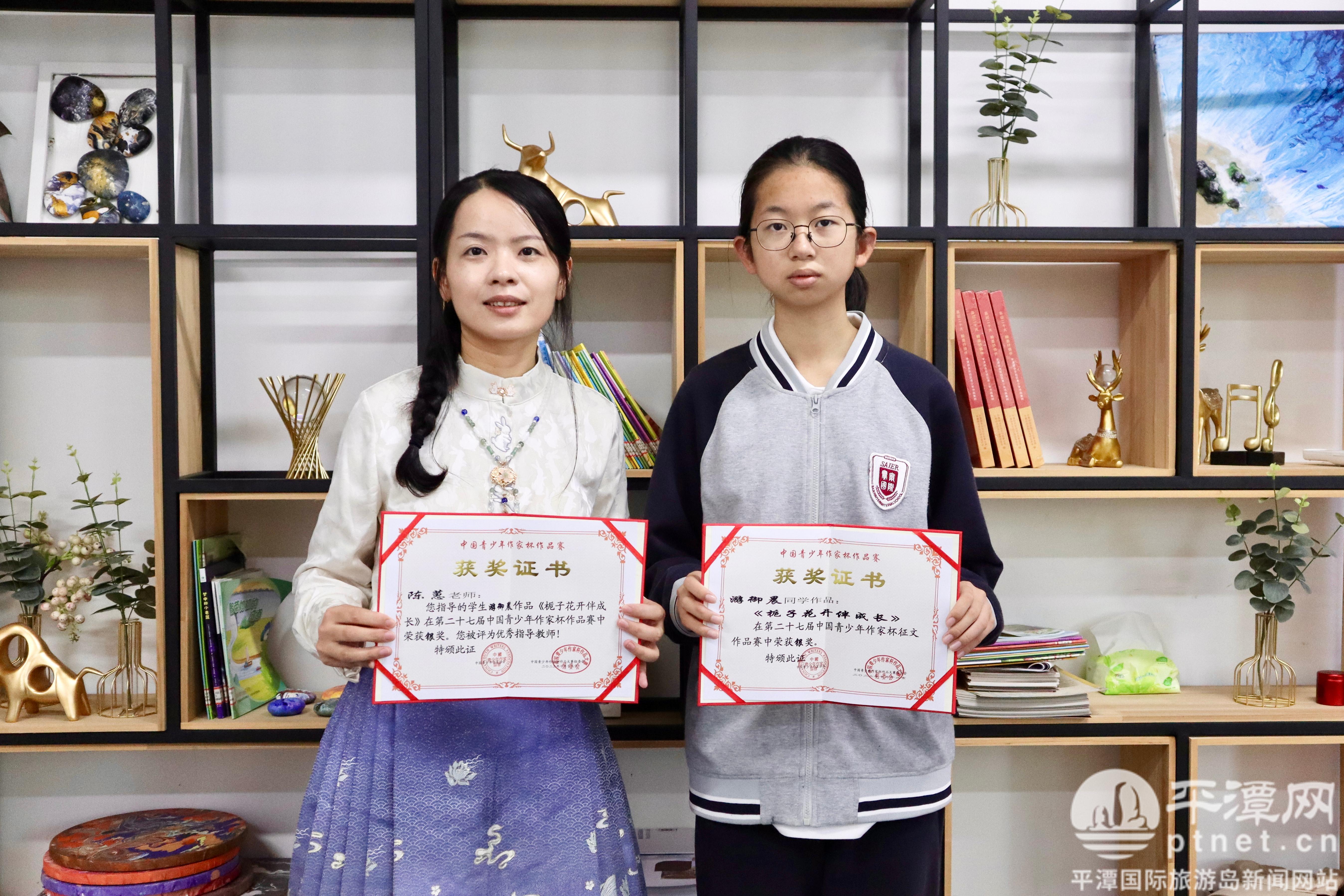 游御晨(右)和指导老师陈蕙捧着荣誉证书合影.